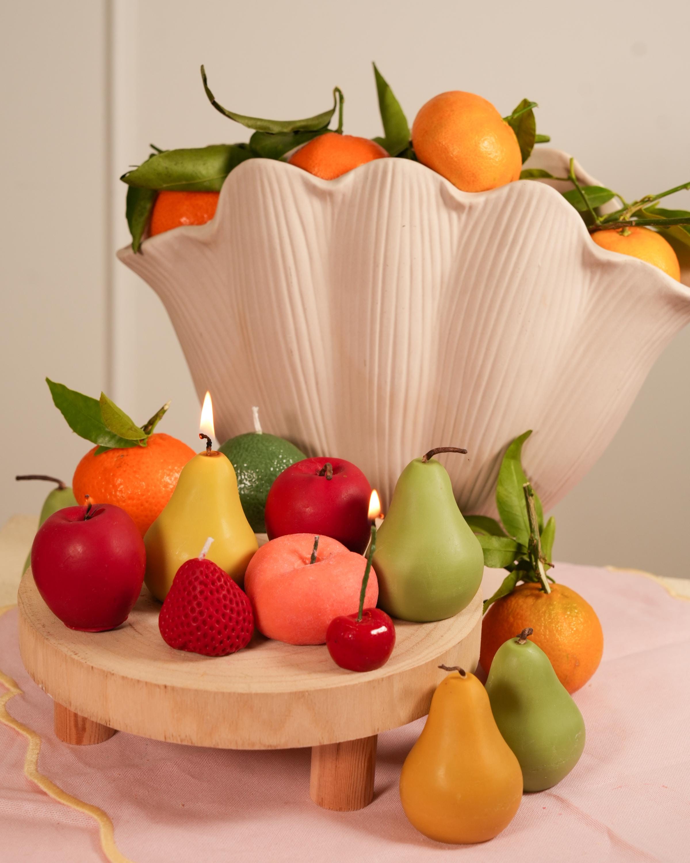 Handmade fruit-shaped candles in soy wax. One-of-a-kind textures, warm glow, and timeless shelf appeal for aesthetic spaces.
