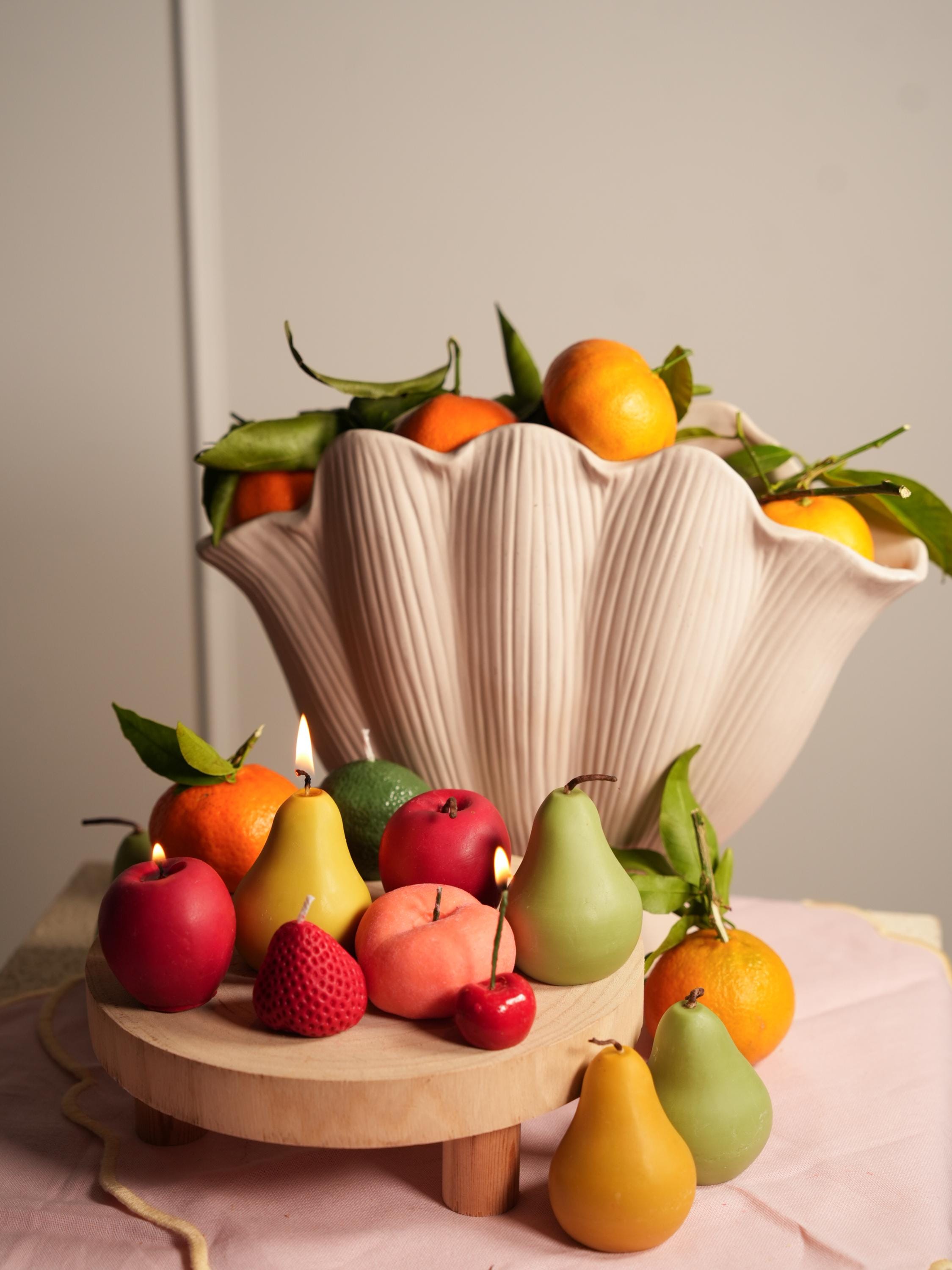 Handmade fruit-shaped candles in soy wax. One-of-a-kind textures, warm glow, and timeless shelf appeal for aesthetic spaces.